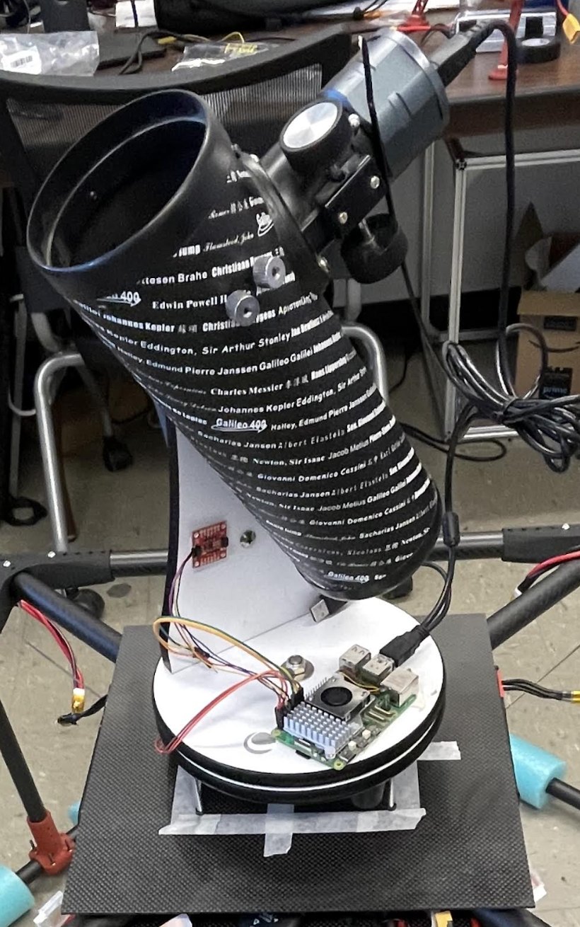 Newtonian telescope tube mounted on the drone payload plate with its control electronics