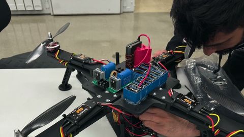 Close-up of the airframe during resonant power transfer testing, showing the coil driver electronics and wiring