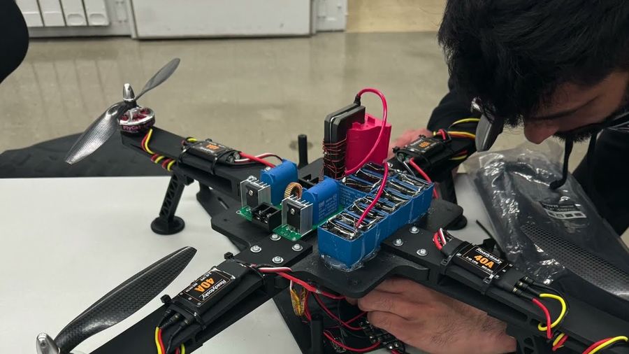 Close-up of the airframe during resonant power transfer testing, showing the coil driver electronics and wiring